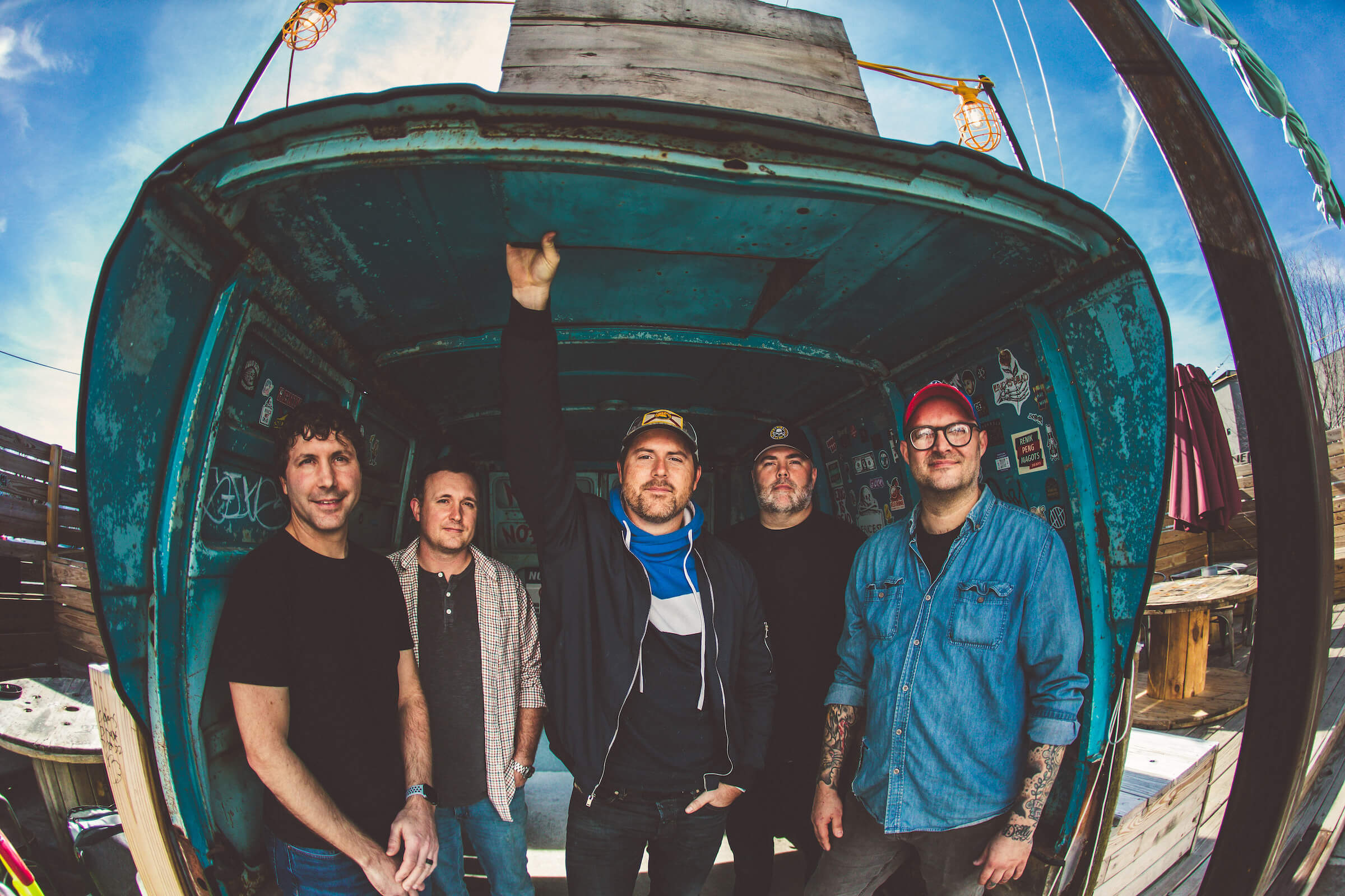 the band members standing inside a van that is cut in half